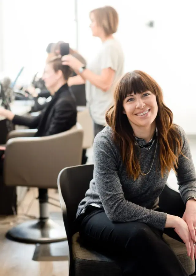 A woman sitting in front of other people.