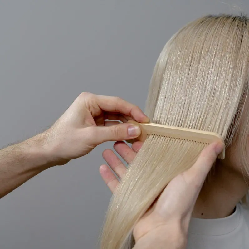 A person is cutting another person 's hair