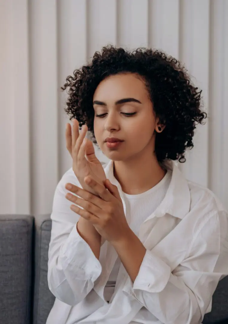 A woman with her hands clasped together.