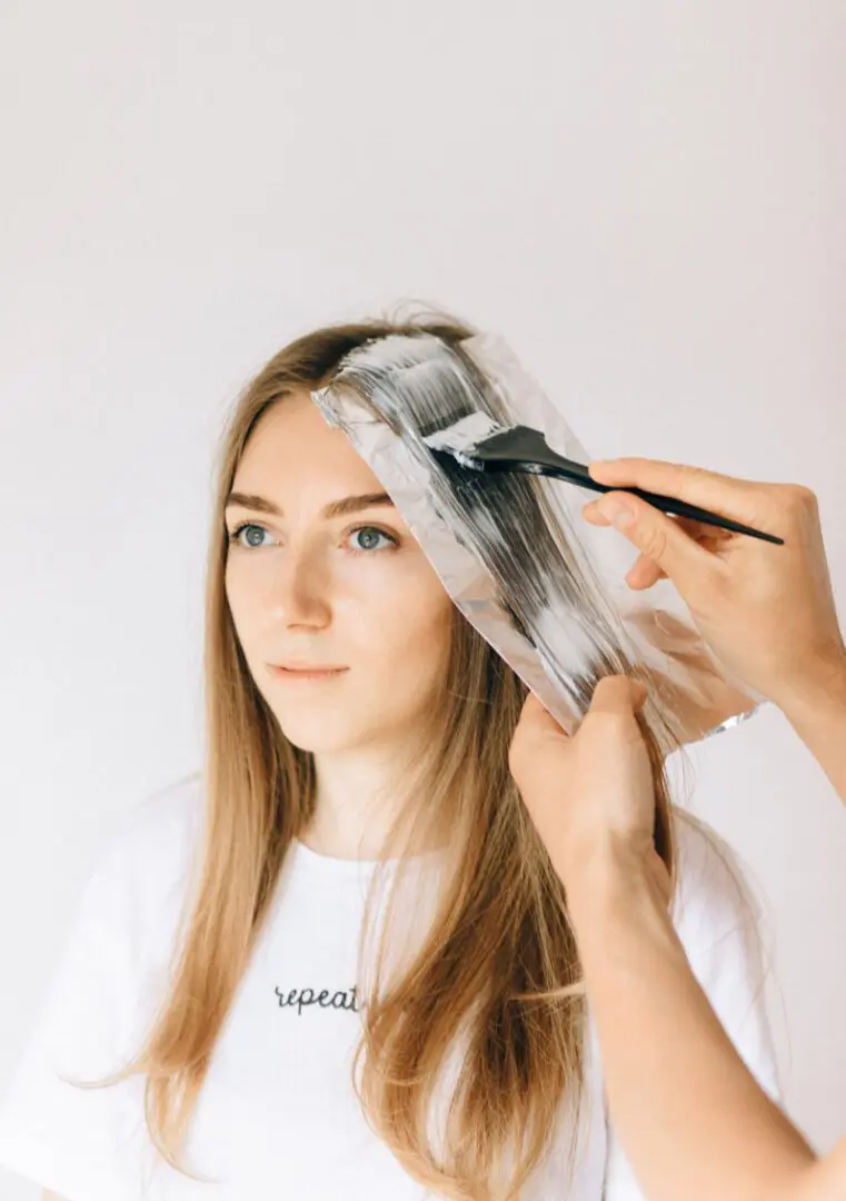 A woman getting her hair cut by another person.