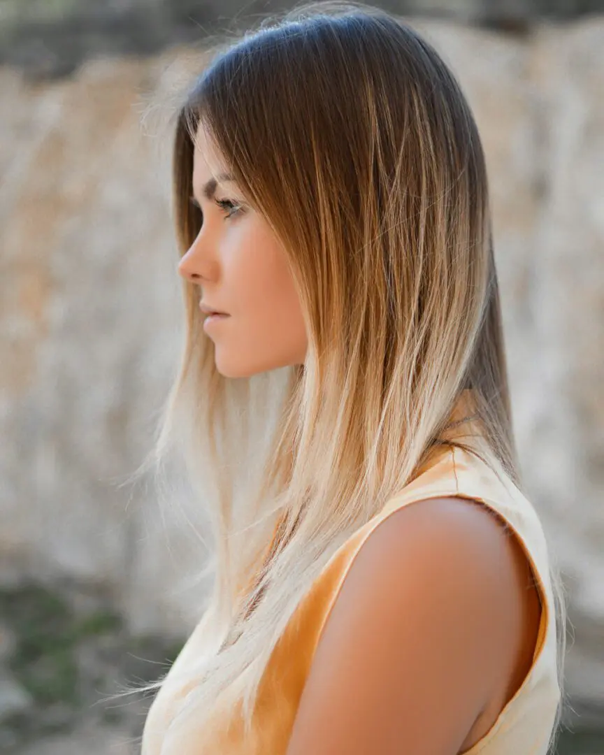 A woman with long hair is looking to her left.