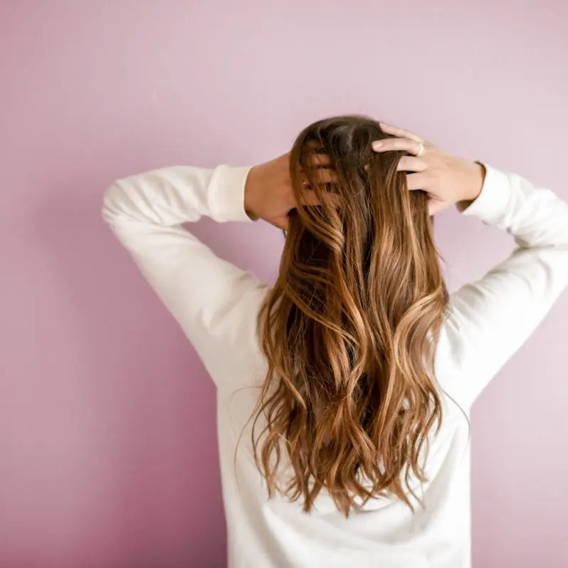 A woman with her hands in her hair.