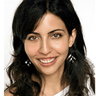 A woman with long black hair wearing earrings.