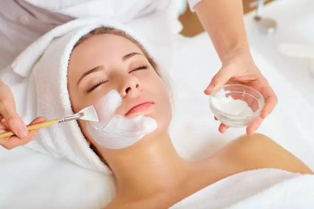 A woman getting her face waxed at the spa