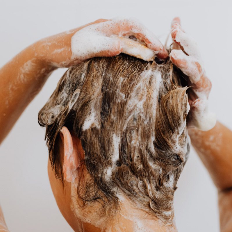 A person washing their hair with soap