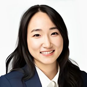 A woman in a suit and tie smiling for the camera.